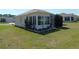 Exterior view of home with a sunroom, surrounded by a well-maintained lawn at 13100 Se 93Rd Terrace Rd, Summerfield, FL 34491