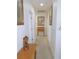 Hallway with tan carpet, white walls with 3 framed art pieces and a small wood desk at 13100 Se 93Rd Terrace Rd, Summerfield, FL 34491