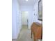 Hallway leading to laundry with a wooden desk and decorative painting on the wall at 13100 Se 93Rd Terrace Rd, Summerfield, FL 34491