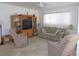 Bright living room featuring neutral carpeting, a ceiling fan, and a sofa with floral design at 13100 Se 93Rd Terrace Rd, Summerfield, FL 34491