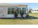 Sunroom with windows surrounded by well-maintained green grass, complemented by small bushes at 13100 Se 93Rd Terrace Rd, Summerfield, FL 34491