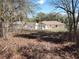 The backyard of a single Gathering home with grass, and mature trees at 1546 Sw 153Rd Sw Ct, Ocala, FL 34481