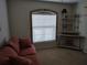 Bedroom with neutral carpet, decor shelves, sofa and arched window with blinds at 1546 Sw 153Rd Sw Ct, Ocala, FL 34481