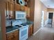 Cozy kitchen with wood cabinets, tile backsplash, and adjacent laundry room, and tile floors at 1546 Sw 153Rd Sw Ct, Ocala, FL 34481