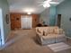 Cozy living room with carpeted floors, ceiling fan, and comfortable floral sofa at 1546 Sw 153Rd Sw Ct, Ocala, FL 34481