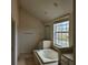 A clean bathroom features a large soaking tub near a bright window with natural light at 162 Riggings Way, Clermont, FL 34711