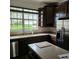 A bright kitchen shows a stainless steel refrigerator, dark cabinets, and a view of the backyard at 162 Riggings Way, Clermont, FL 34711