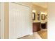 Bathroom featuring double sinks, vanity area, framed mirrors next to closet at 16276 Sw 14Th Ct, Ocala, FL 34473