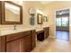 Bathroom featuring double sinks, vanity area, framed mirrors with view to the bedroom at 16276 Sw 14Th Ct, Ocala, FL 34473