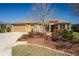 Charming single-story home featuring a three-car garage, manicured lawn, and colorful landscaping at 16276 Sw 14Th Ct, Ocala, FL 34473