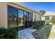 Rear exterior view showcasing a covered patio with sliding glass doors and tidy landscaping at 16276 Sw 14Th Ct, Ocala, FL 34473