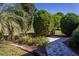 Beautiful landscaping showcasing lush greenery, including shrubs and trees, along a brick paver walkway at 16276 Sw 14Th Ct, Ocala, FL 34473