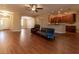 Open-concept living room with wood floors, a ceiling fan, and a view into the adjacent kitchen at 16276 Sw 14Th Ct, Ocala, FL 34473