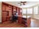 Office with custom wooden built-in shelves, desk, wood floors, and shuttered windows, creating a functional workspace at 16276 Sw 14Th Ct, Ocala, FL 34473