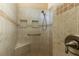 Walk-in shower featuring tiled walls, built-in shelves, a seating bench, and a sleek shower head at 16276 Sw 14Th Ct, Ocala, FL 34473