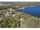 Aerial view of a lakefront property surrounded by lush trees at 17153 Se 79Th Street Rd, Ocklawaha, FL 32179