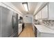 Galley kitchen featuring stainless steel appliances, mosaic backsplash, and bright white cabinets at 17153 Se 79Th Street Rd, Ocklawaha, FL 32179