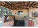 Undercover outdoor kitchen area featuring a grill, sink, fan, and bar seating at 17153 Se 79Th Street Rd, Ocklawaha, FL 32179