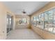 Sunroom with white tile flooring, ceiling fan and views of the property's garden at 17153 Se 79Th Street Rd, Ocklawaha, FL 32179