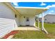 Enclosed back porch featuring a secure door, concrete patio, and red rock landscaping at 17421 Se 107Th Ct, Summerfield, FL 34491