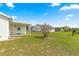 Spacious back yard with lush grass, a mature tree, and a covered back porch at 17421 Se 107Th Ct, Summerfield, FL 34491