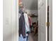 This closet has a light switch and the closet is full of hanging clothes and miscellaneous storage items at 17421 Se 107Th Ct, Summerfield, FL 34491