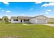 Lush green front lawn with a driveway leading to an attached garage at 17421 Se 107Th Ct, Summerfield, FL 34491