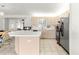 This kitchen features stainless steel appliances, a light-colored backsplash, a center island, and light-colored cabinets at 17421 Se 107Th Ct, Summerfield, FL 34491