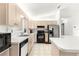 This kitchen features tile floors, light colored cabinets and countertops, and black appliances at 17421 Se 107Th Ct, Summerfield, FL 34491