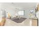 Bright living room with neutral tones, a ceiling fan, and a large window at 17421 Se 107Th Ct, Summerfield, FL 34491