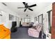 Spacious living room featuring multiple ceiling fans, a large window, and carpet flooring at 17421 Se 107Th Ct, Summerfield, FL 34491