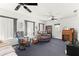 Cozy living room with three ceiling fans, natural light, and carpet flooring at 17421 Se 107Th Ct, Summerfield, FL 34491