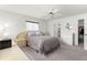 Bright main bedroom featuring neutral carpeting, a ceiling fan, and ample natural light from one window at 17421 Se 107Th Ct, Summerfield, FL 34491