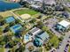 Expansive aerial view of community amenities featuring tennis courts, pool, baseball field, and lake at 17818 Se 120Th Ct, Summerfield, FL 34491