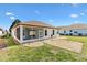 Backyard featuring decorative gravel, a well-maintained lawn, and a screened-in lanai at 17818 Se 120Th Ct, Summerfield, FL 34491