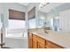 Bathroom featuring a soaking tub, double sink vanity, and plenty of natural light at 17818 Se 120Th Ct, Summerfield, FL 34491