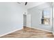 Spacious bedroom featuring wood floors, a door to another room and a window with blinds at 17818 Se 120Th Ct, Summerfield, FL 34491