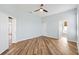 Spacious bedroom featuring a ceiling fan, an open floor plan, and wood-look flooring at 17818 Se 120Th Ct, Summerfield, FL 34491