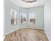 Bright bedroom featuring wood floors, ceiling fan and natural light from three large windows at 17818 Se 120Th Ct, Summerfield, FL 34491