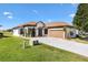 Charming single-story home with well-manicured lawn, brown accents, and a two-car garage at 17818 Se 120Th Ct, Summerfield, FL 34491