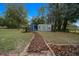 Backyard view of the property featuring versatile storage sheds amidst a backdrop of lush greenery and landscaping at 1905 Nw 25Th Ave, Ocala, FL 34475