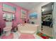 Bathroom featuring a soaking tub, pink walls, and a walk-in closet at 1905 Nw 25Th Ave, Ocala, FL 34475