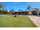 Spacious front yard and charming front exterior with decorative landscaping and wooden porch columns at 1905 Nw 25Th Ave, Ocala, FL 34475