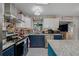 Modern kitchen with a blue and white color scheme, granite countertops, and stainless steel appliances at 1905 Nw 25Th Ave, Ocala, FL 34475