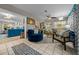 Cozy living room featuring a plush blue chair, decorative rug, and an open view to the kitchen at 1905 Nw 25Th Ave, Ocala, FL 34475