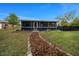 The property features a blue screened porch extending into a well-maintained lawn with decorative landscaping at 1905 Nw 25Th Ave, Ocala, FL 34475