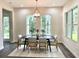 Elegant dining room with a modern chandelier, neutral color palette, and views of the backyard at 1955 Nw 79Th Loop, Ocala, FL 34475