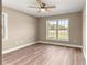 Bedroom featuring wood-look floors, a ceiling fan, neutral paint, and a window with a view at 20396 Sw 79Th Lane, Dunnellon, FL 34431