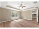 Bedroom featuring a large window, tray ceiling and wood-look flooring at 20396 Sw 79Th Lane, Dunnellon, FL 34431