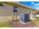 Close-up of the home's exterior featuring the air conditioning unit and outdoor utility connections at 20396 Sw 79Th Lane, Dunnellon, FL 34431